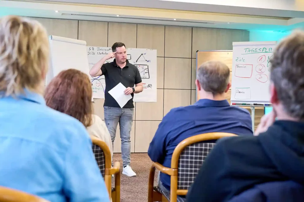 Ein Mann präsentiert etwas bei einem Live-Seminar vor dem Publikum