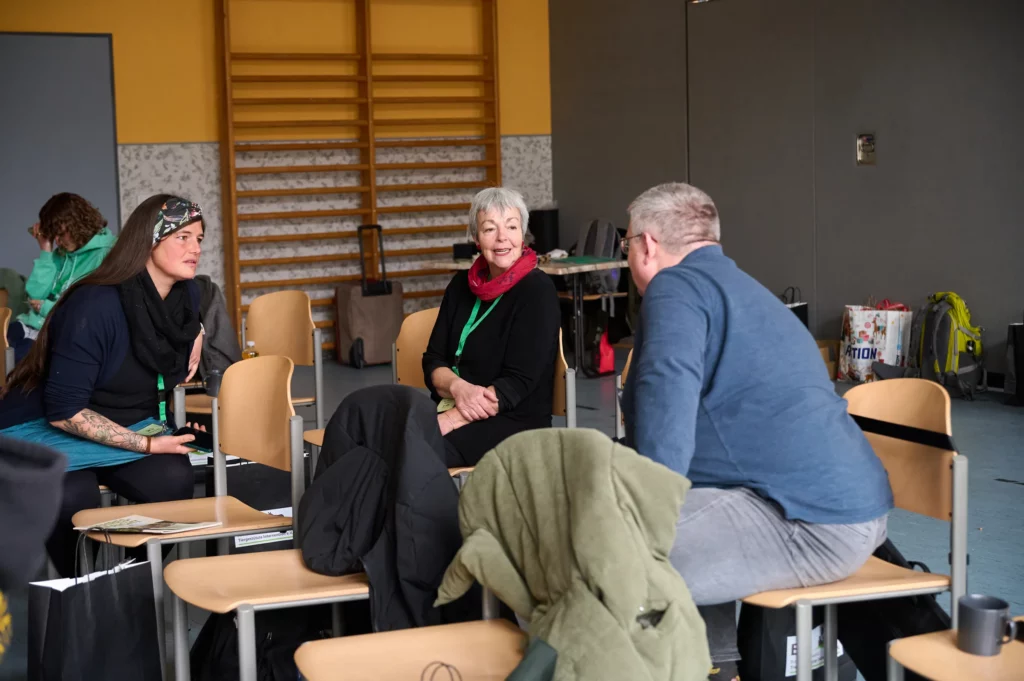 Zwei Frauen besprechen etwas mit einem Mann bei der BTI-Fachtagung