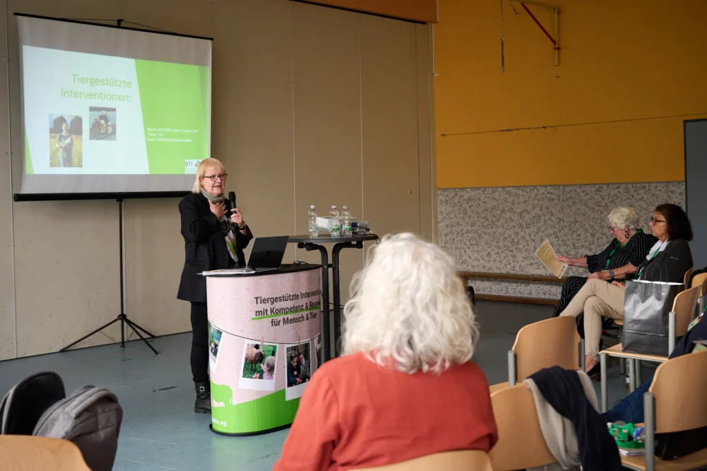 Eine Frau spricht vor dem Publikum, eine hält ein Mikrofon