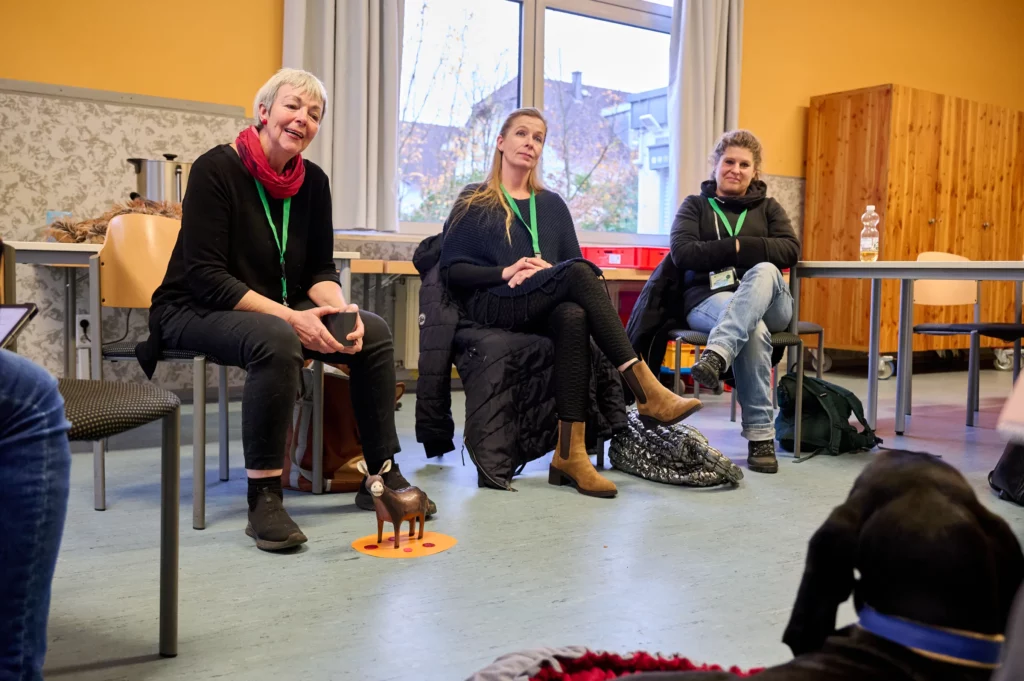 Drei Frauen sitzen und hören aufmerksam bei der BTI-Fachtagung zu